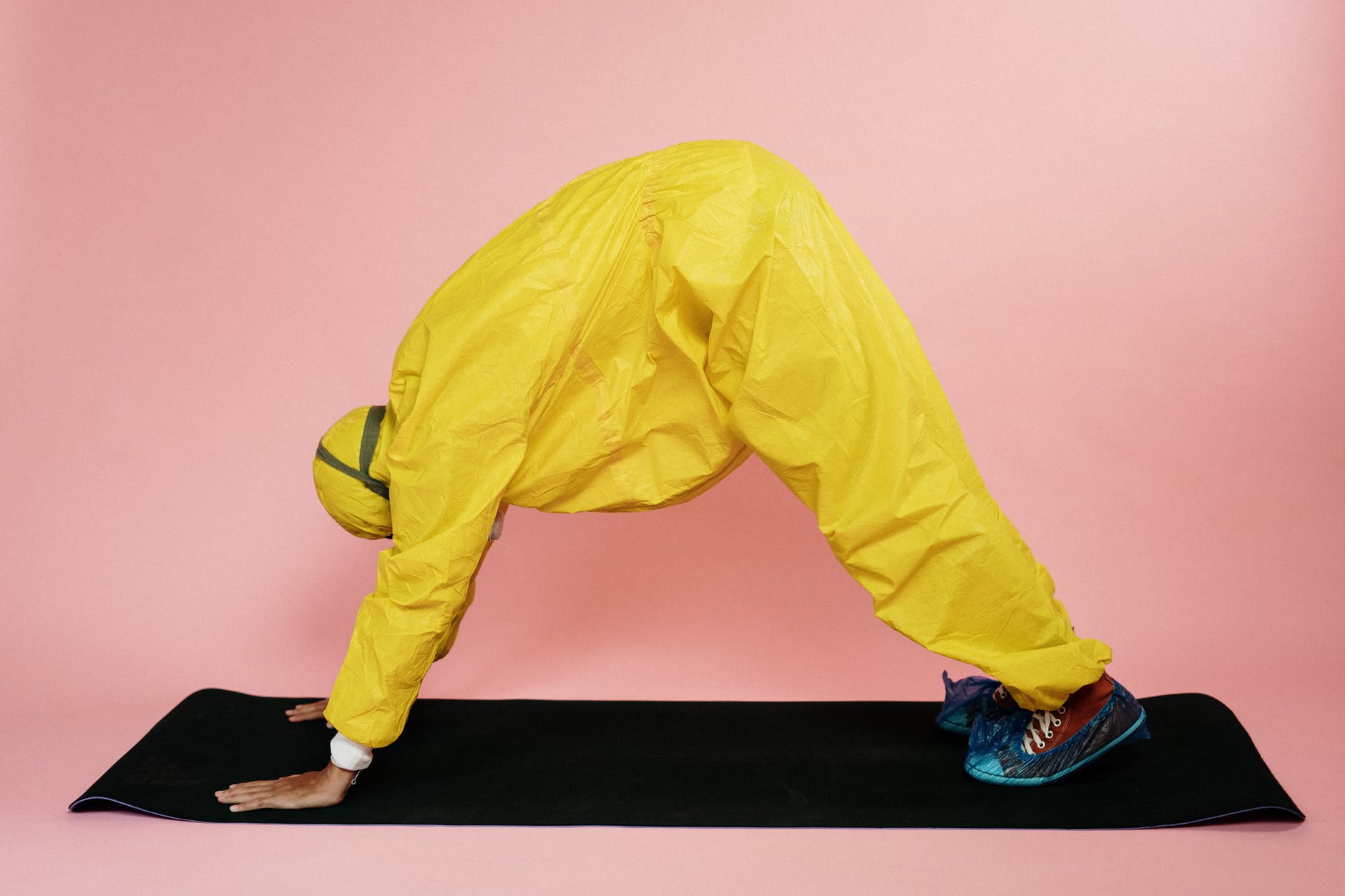 person in yellow protective suit doing a yoga pose